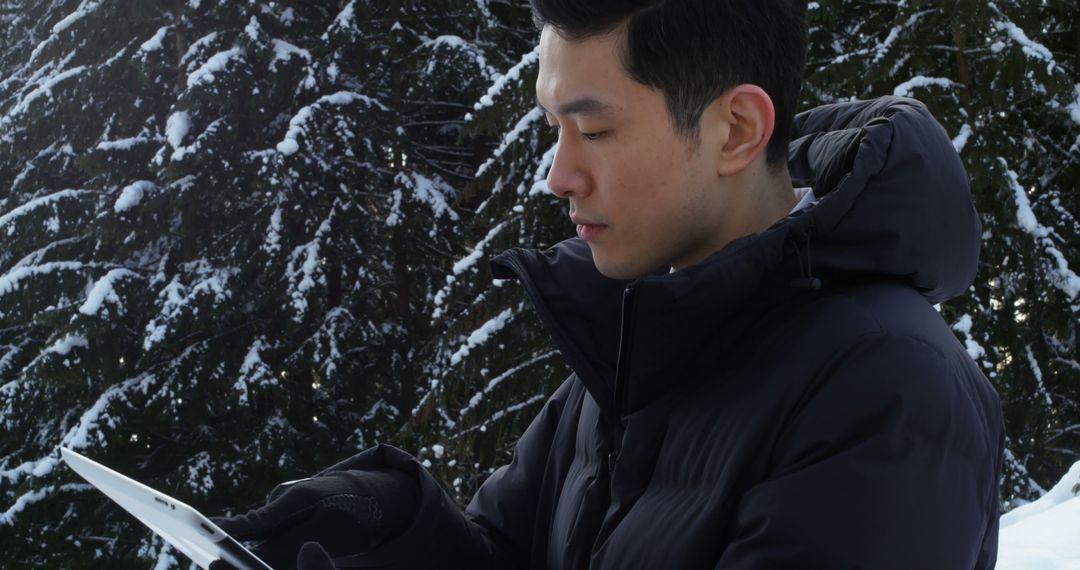 Young Man Using Tablet in Snowy Forest - Free Images, Stock Photos and Pictures on Pikwizard.com