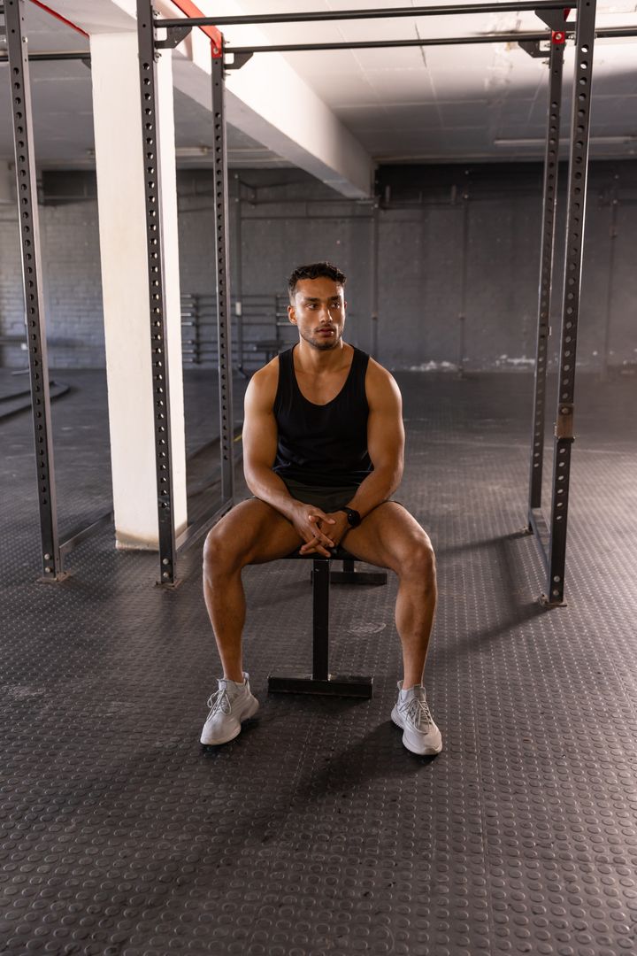 Fit Man Sitting on Gym Bench, Ready for Workout