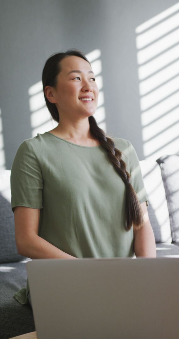 Smiling Asian Woman Working from Home with Laptop