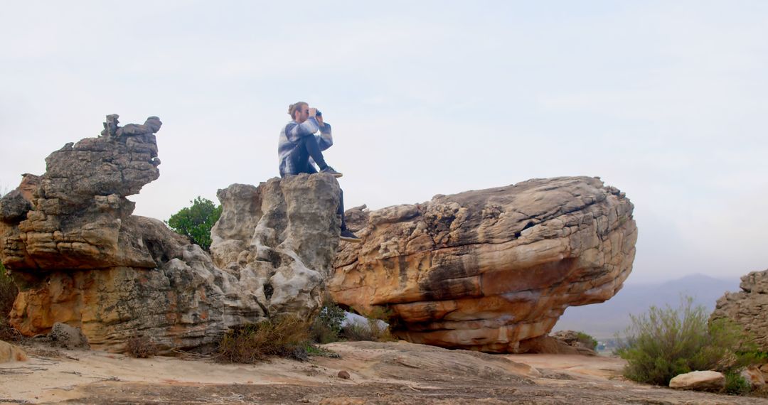 Hiker Sitting on Large Rock Formation Enjoying Scenic View - Free Images, Stock Photos and Pictures on Pikwizard.com