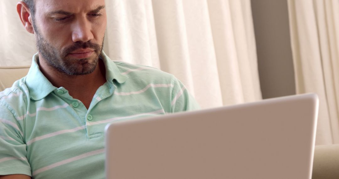 Focused man using laptop at home - Free Images, Stock Photos and Pictures on Pikwizard.com