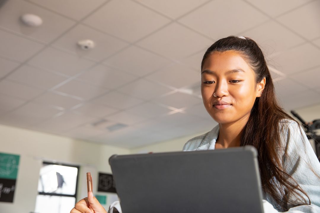 Student in Modern Classroom Studying On Laptop With Focus