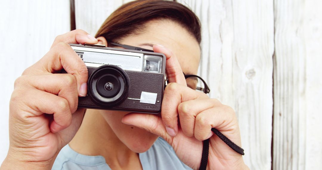 A middle-aged Caucasian woman is taking a photograph with a vintage camera, with copy space - Free Images, Stock Photos and Pictures on Pikwizard.com
