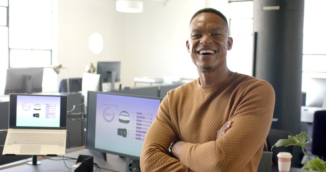 Confident Businessman Smiling in Modern Office with Computers