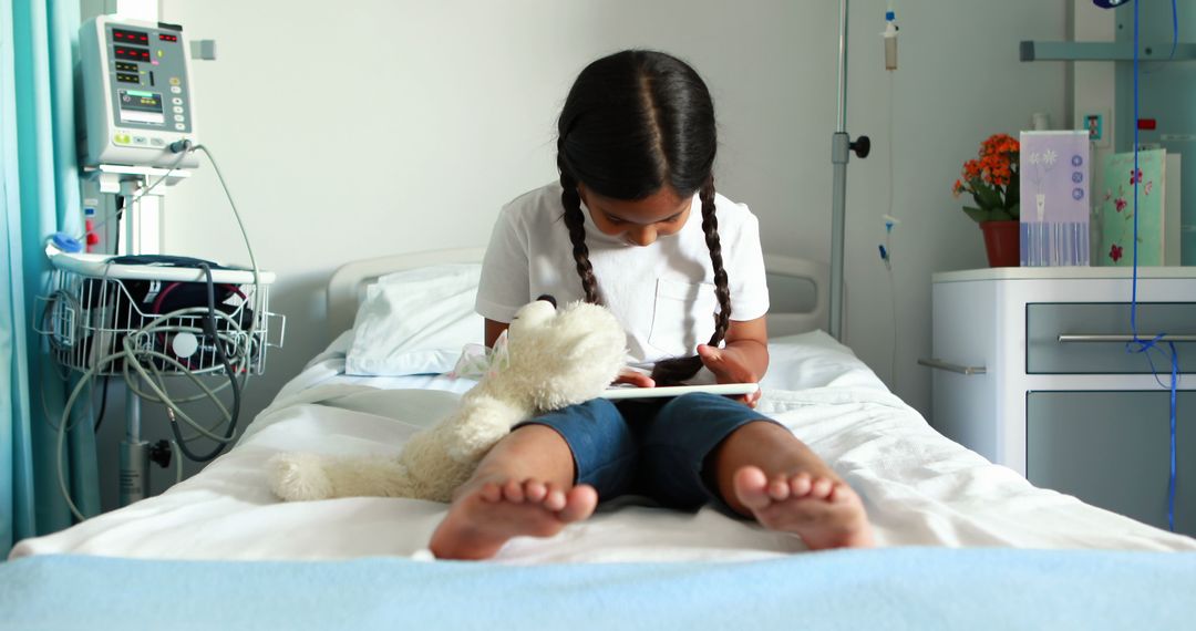 Young Girl in Hospital Bed Using Tablet with Teddy Bear Companion - Free Images, Stock Photos and Pictures on Pikwizard.com