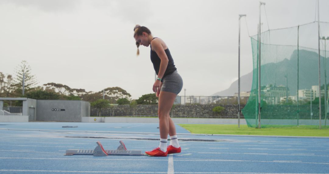 Female Athlete Getting Ready in Track Starting Position - Free Images, Stock Photos and Pictures on Pikwizard.com