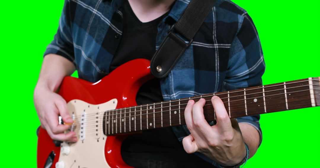 Guitarist Playing Electric Guitar Solo in Plaid Shirt with Green Screen Background - Free Images, Stock Photos and Pictures on Pikwizard.com