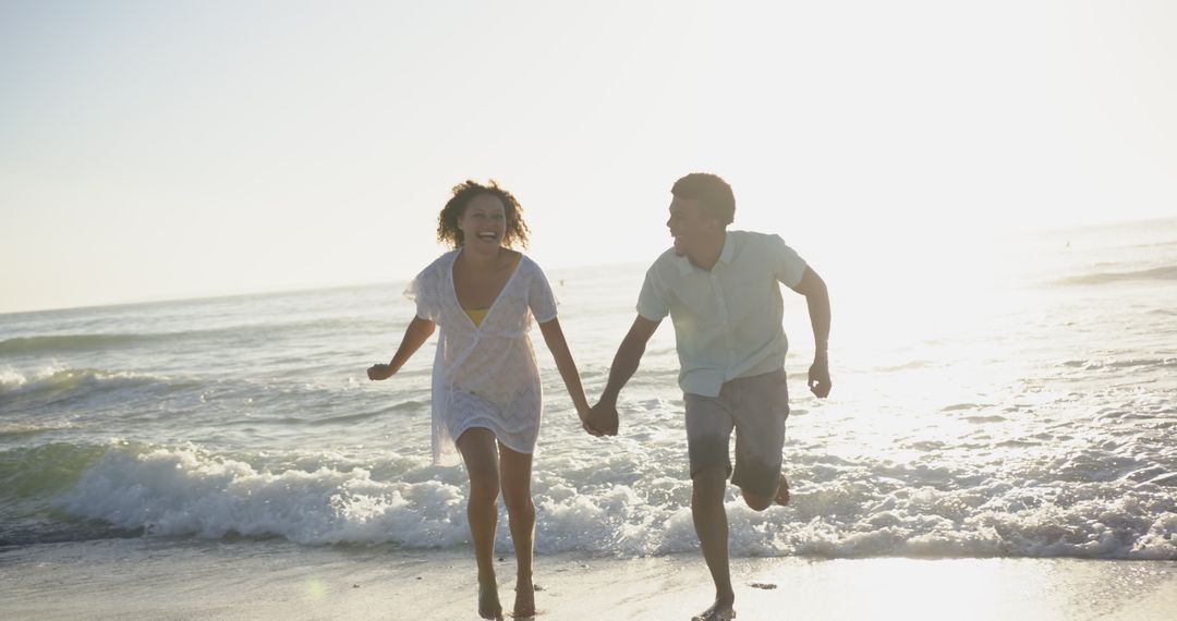 Couple Joyfully Running on Beach at Sunset