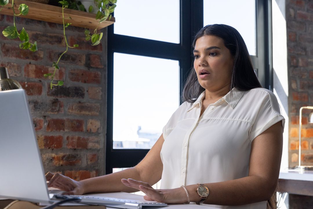 Woman In Office Using Laptop With Surprised Expression