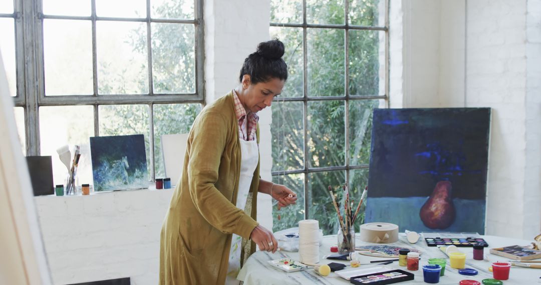 Woman Creating Art in Studio Near Large Windows - Free Images, Stock Photos and Pictures on Pikwizard.com