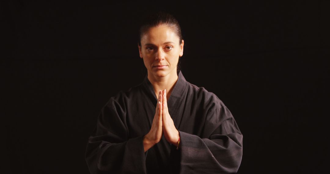 Karate player in prayer pose against black background - Free Images, Stock Photos and Pictures on Pikwizard.com