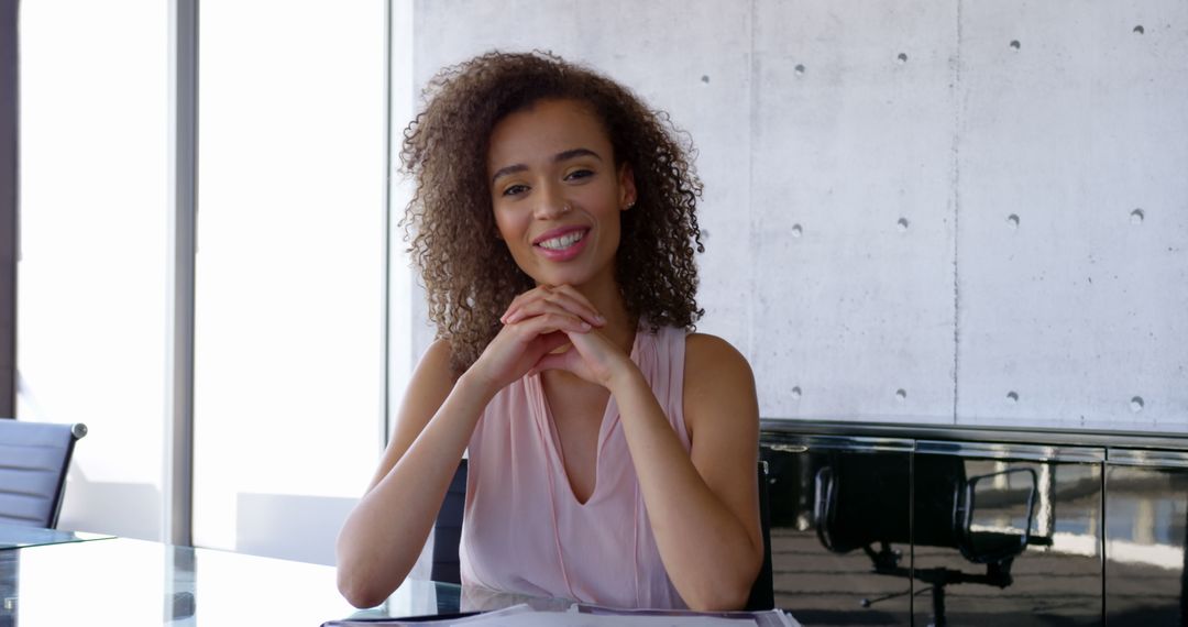 Confident Businesswoman Smiling at Office Desk with Documents