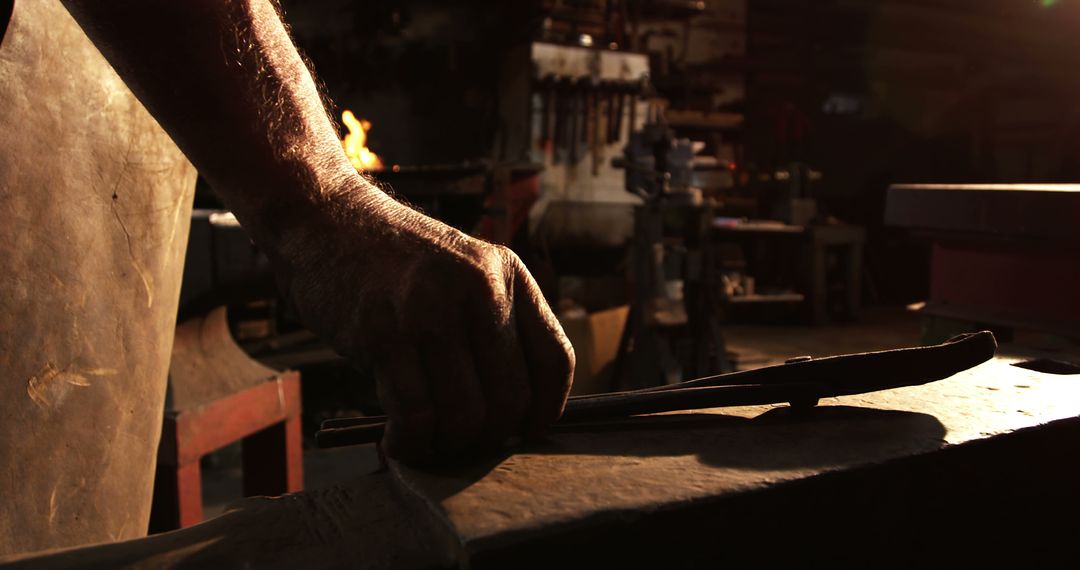 Blacksmith Hand Crafting Metal In Workshop With Low Light Ambiance - Free Images, Stock Photos and Pictures on Pikwizard.com