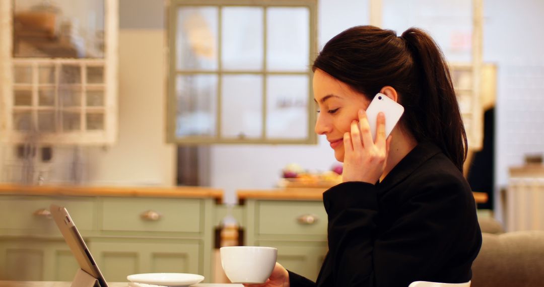 Businesswoman Speaking on Phone While Having Coffee in Café - Free Images, Stock Photos and Pictures on Pikwizard.com