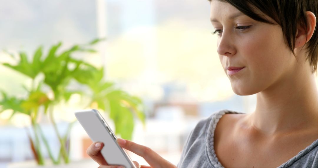 Woman Using Smartphone in Bright Modern Office - Free Images, Stock Photos and Pictures on Pikwizard.com