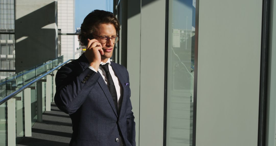 Confident Businessman Taking a Call in Modern Office Corridor - Free Images, Stock Photos and Pictures on Pikwizard.com