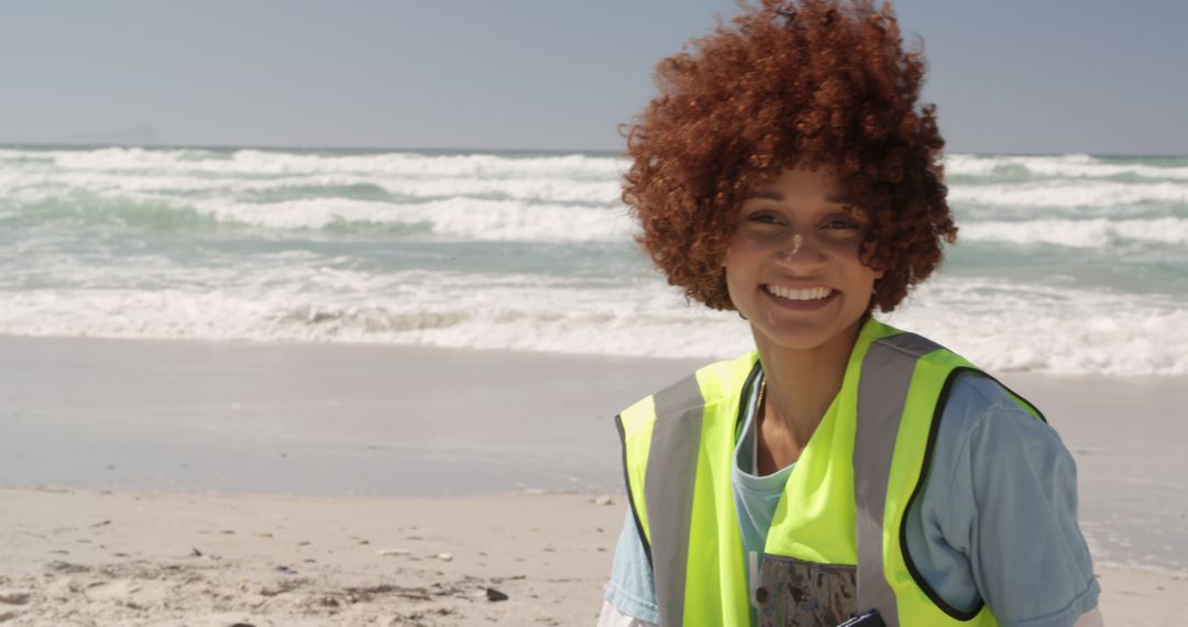 Smiling Volunteer Cleaning Beach with Ocean Waves - Free Images, Stock Photos and Pictures on Pikwizard.com