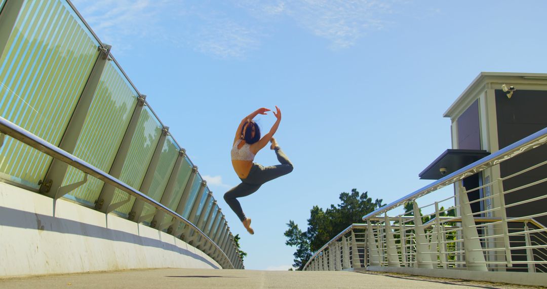 Young Woman Performing Dance Jump on Bridge - Free Images, Stock Photos and Pictures on Pikwizard.com