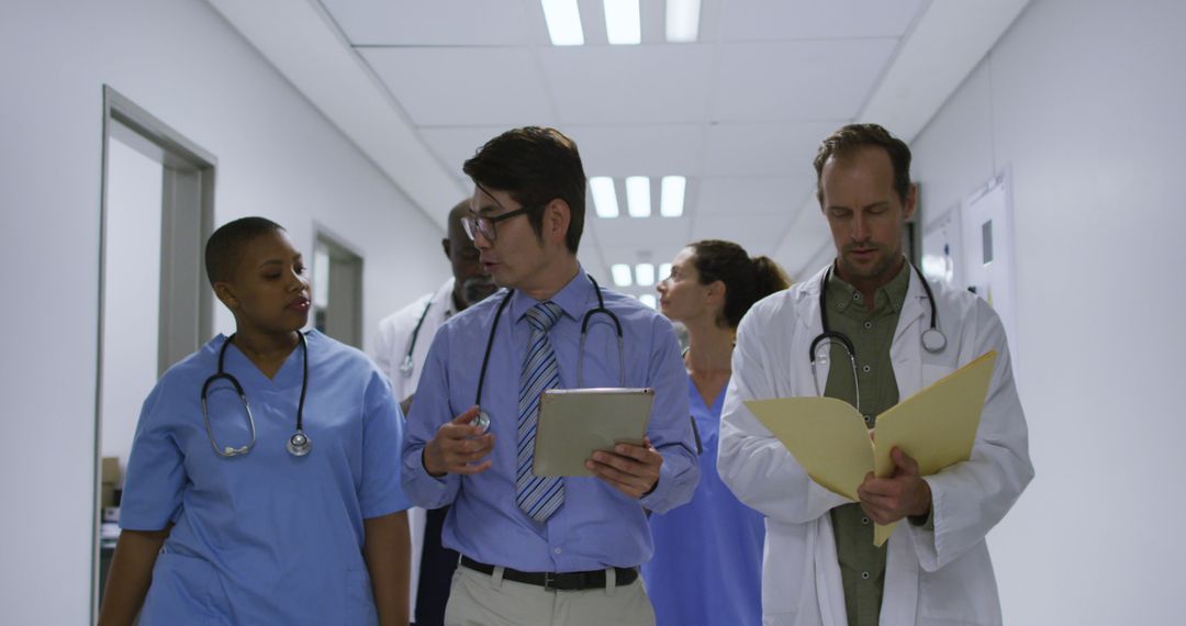 Diverse Medical Team Discussing Patient Care in Hospital Corridor - Free Images, Stock Photos and Pictures on Pikwizard.com