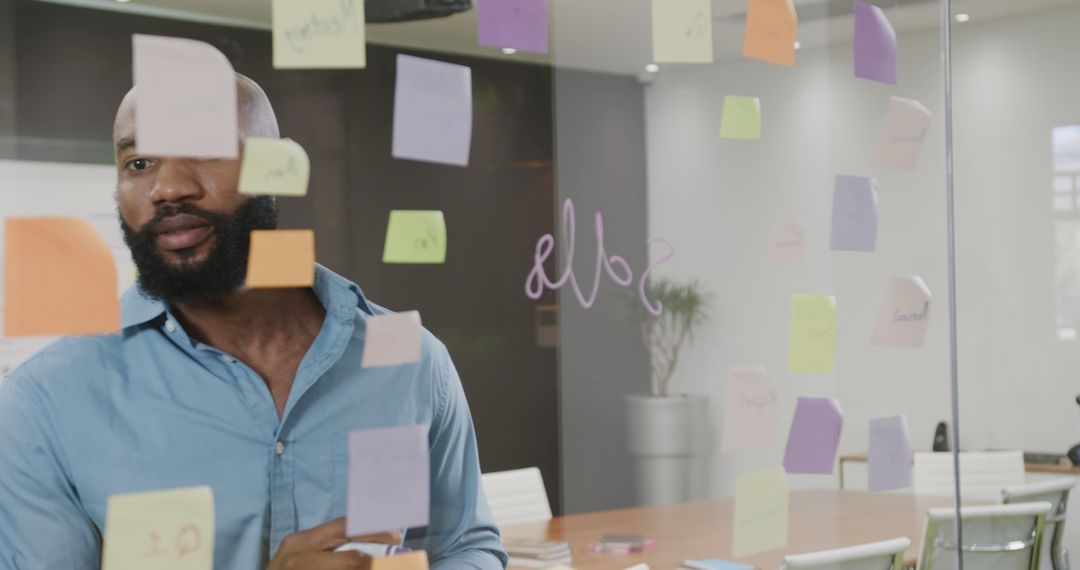 Businessman Planning with Sticky Notes on Office Glass Wall - Free Images, Stock Photos and Pictures on Pikwizard.com