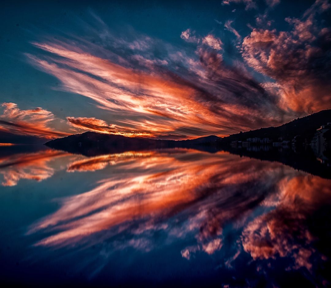 Stunning Sunset Reflection on Calm Lake with Vibrant Clouds - Free Images, Stock Photos and Pictures on Pikwizard.com