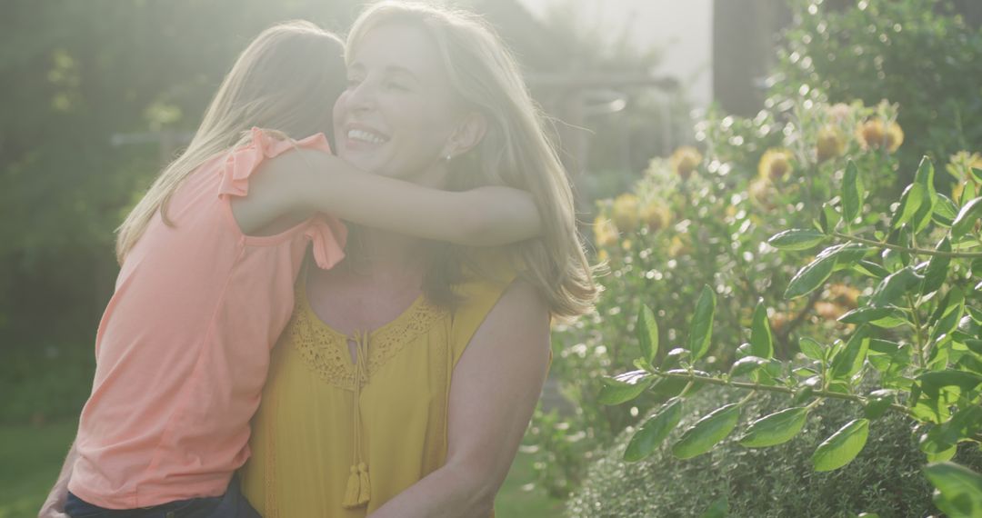 Joyful Mother and Daughter Embracing in Sunlit Garden - Free Images, Stock Photos and Pictures on Pikwizard.com