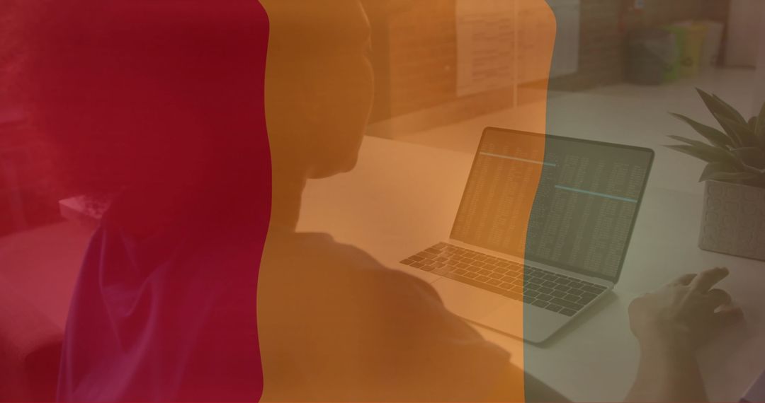 Guinea Flag Overlaying Professional at Work with Laptop