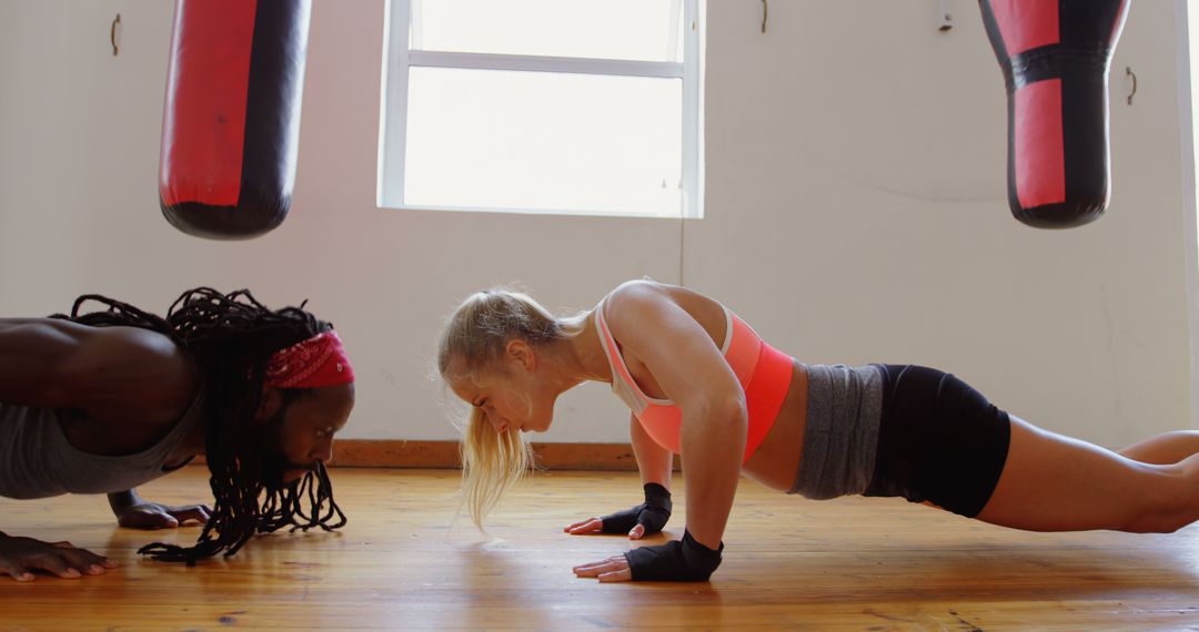 Diverse Fitness Enthusiasts Doing Push-Ups in Gym Setting - Free Images, Stock Photos and Pictures on Pikwizard.com