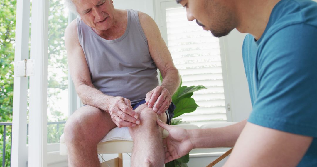 Elderly man receiving knee treatment from male physiotherapist - Free Images, Stock Photos and Pictures on Pikwizard.com