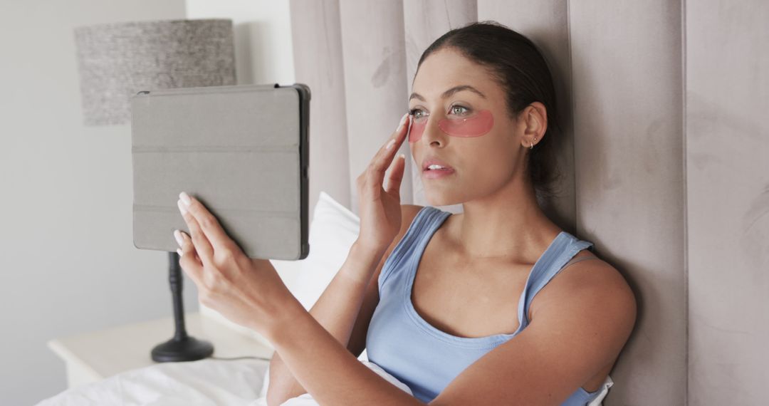 Woman Applying Eye Mask Patches in Bed with Tablet - Free Images, Stock Photos and Pictures on Pikwizard.com