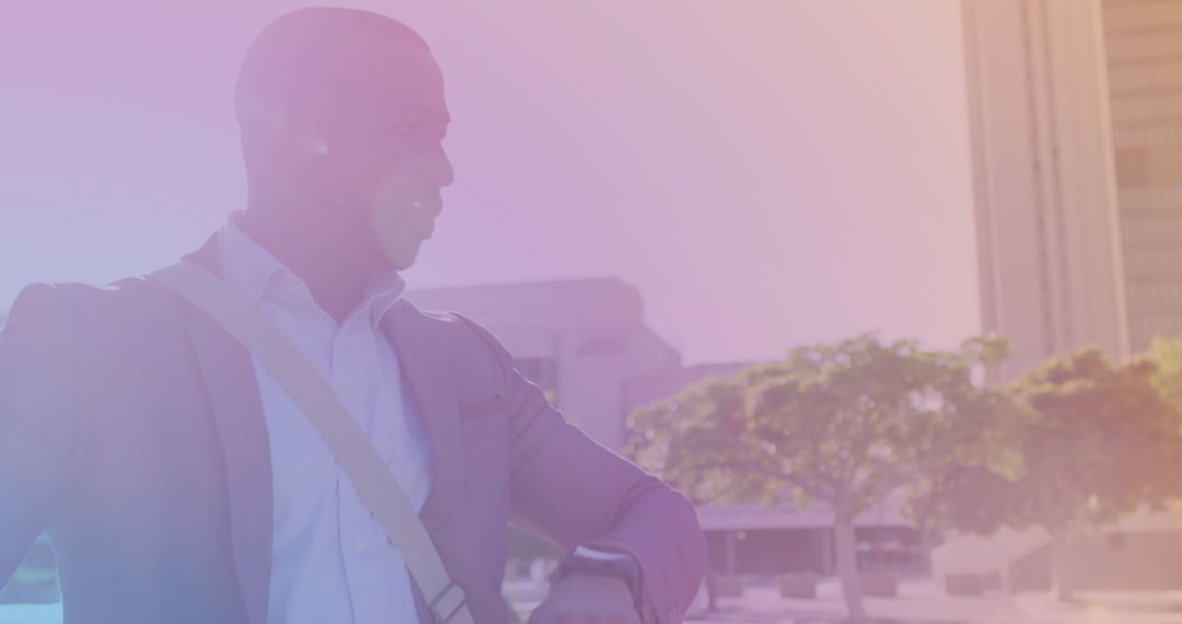Blurred African American Man with Bicycle Using Smartwatch Outdoors