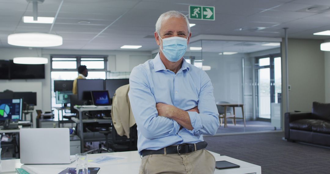 Confident Senior Businessman Wearing Face Mask Standing in Modern Office - Free Images, Stock Photos and Pictures on Pikwizard.com