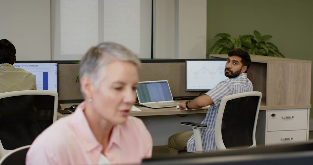 Open Plan Office with Diverse Team Using Dual Monitors for Collaboration