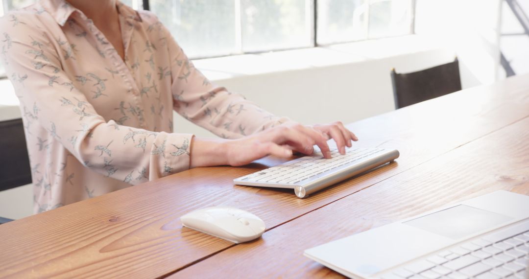 User Typing on Wireless Keyboard in Bright Office