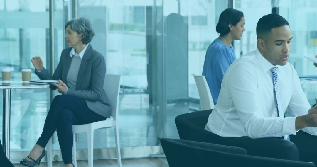 Businessman Checking Phone while Professionals Wait in Modern Glass Office Lobby