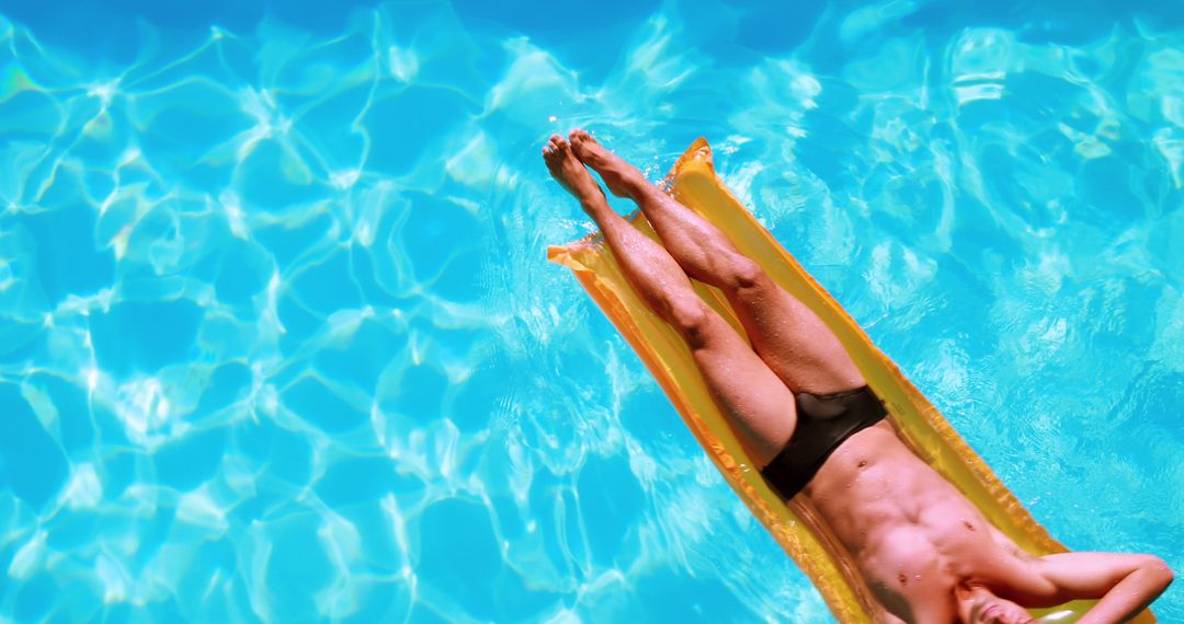 Fit Man Relaxing on Inflatable Lilo in Clear Pool Waters - Free Images, Stock Photos and Pictures on Pikwizard.com