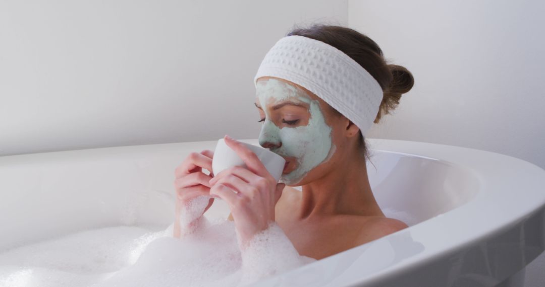 Woman Relaxing in Bathtub with Facial Mask and Tea - Free Images, Stock Photos and Pictures on Pikwizard.com