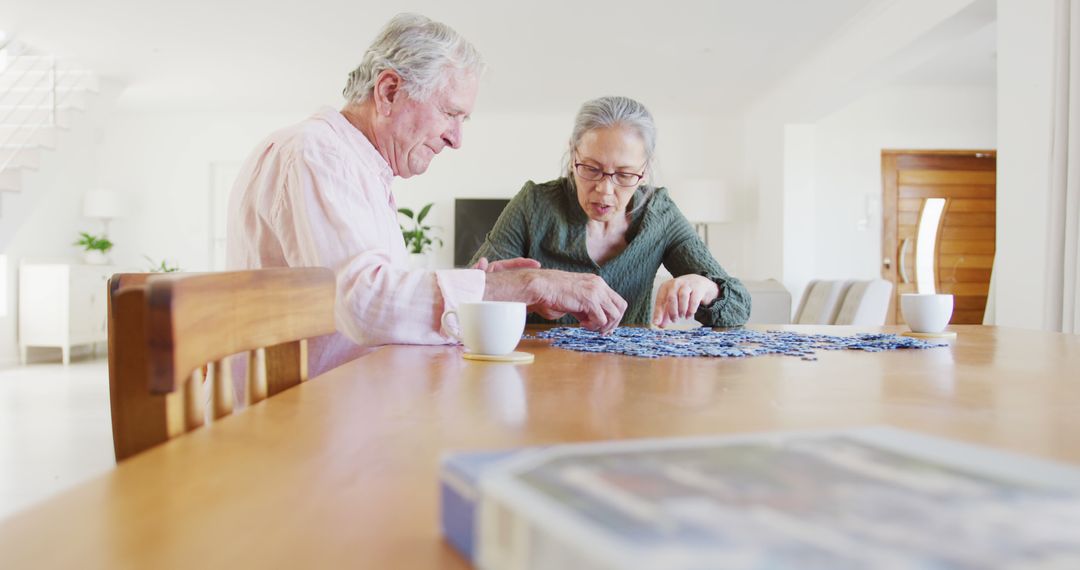 Senior Couple Assembling Puzzle at Home, Enjoying Leisure Time Together - Free Images, Stock Photos and Pictures on Pikwizard.com