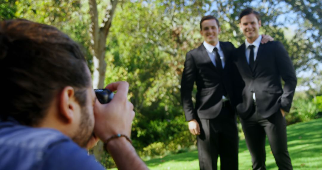 Photographer Capturing Two Men in Suits Outdoors - Free Images, Stock Photos and Pictures on Pikwizard.com