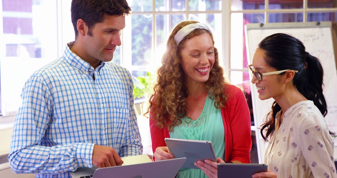 Young Professionals Collaborating with Technology in Bright Office