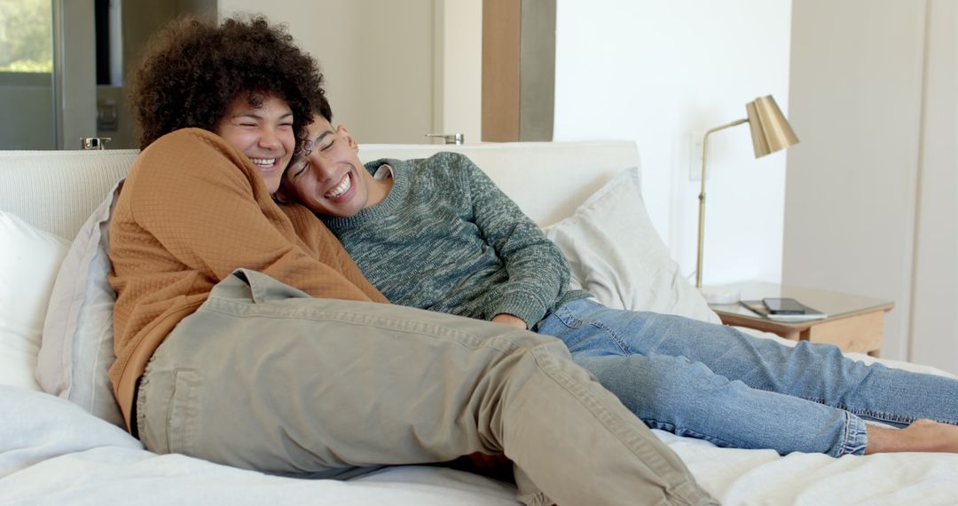 Smiling Couple Relaxing on Bed with Tablet in Modern Bedroom