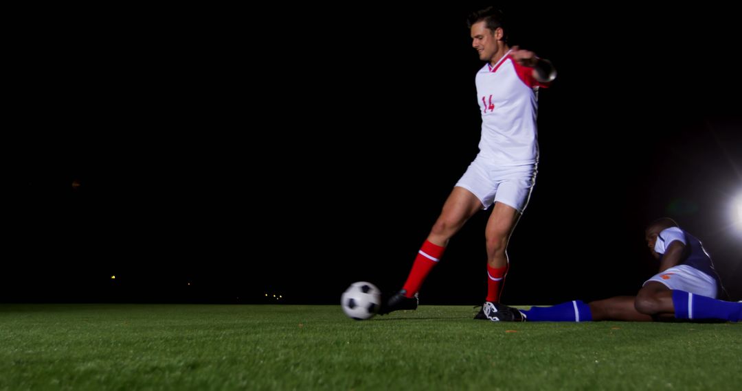 Soccer Player Kicking Ball During Night Match - Free Images, Stock Photos and Pictures on Pikwizard.com