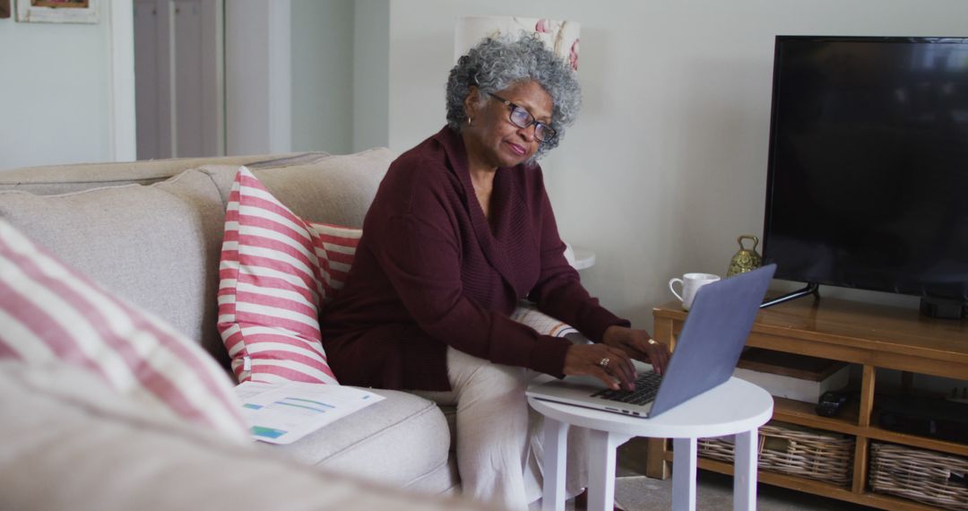 Senior Woman Using Laptop on Couch in Cozy Home Setting - Free Images, Stock Photos and Pictures on Pikwizard.com