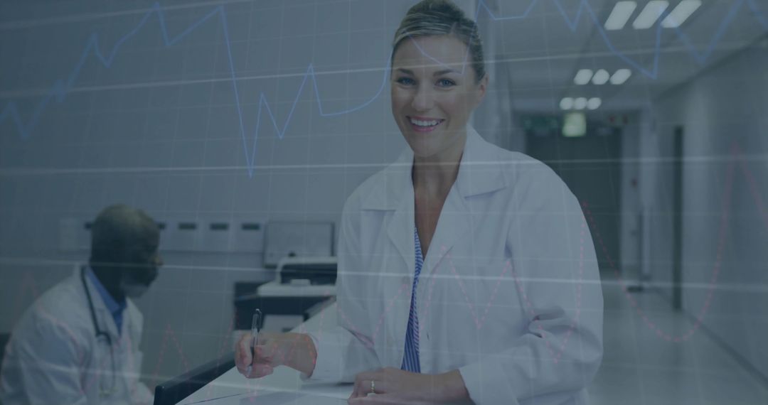 Smiling clinician completing patient paperwork at hospital reception desk with stethoscope