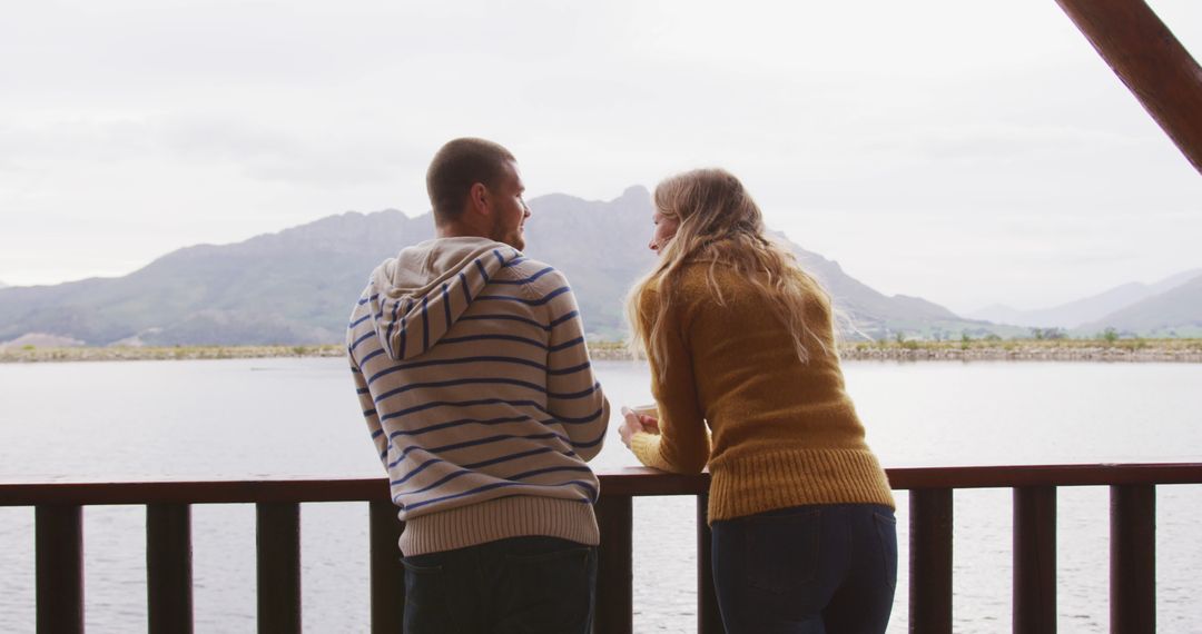 Couple Relaxing on Cabin Balcony Overlooking Scenic Lake