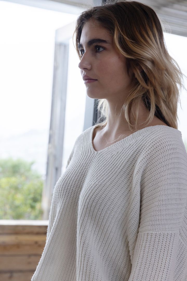 Woman in White Knit Sweater Posing by Window at Home
