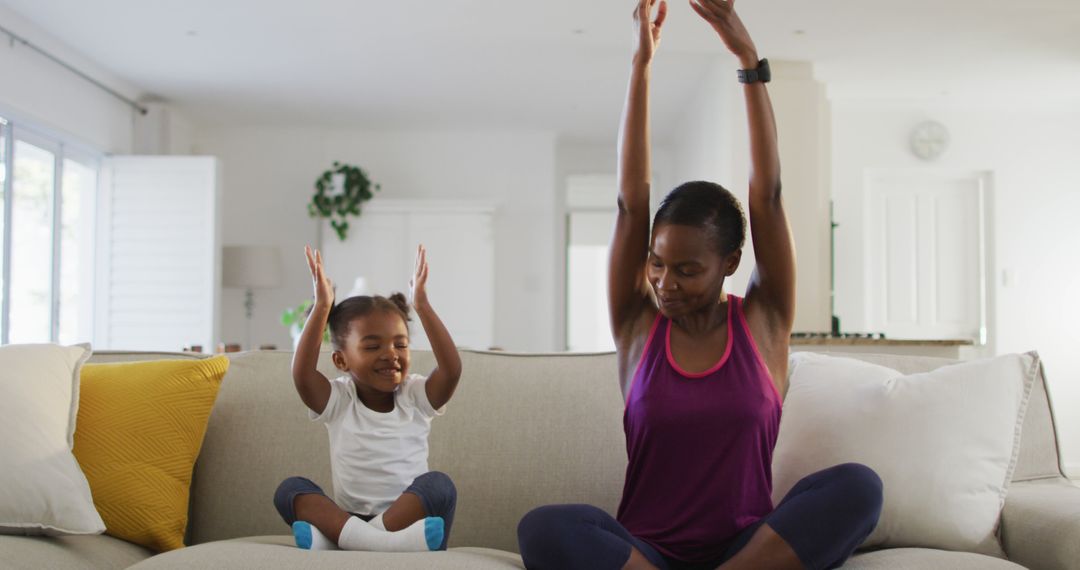 Mother and Daughter Enjoying Yoga Together on Sofa at Home - Free Images, Stock Photos and Pictures on Pikwizard.com