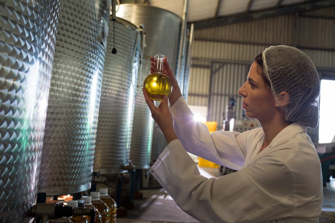 Female technician examining olive oil - Free Images, Stock Photos and Pictures on Pikwizard.com