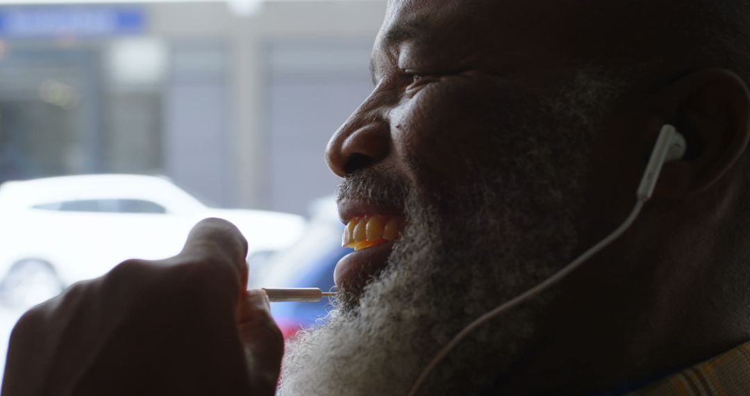 Smiling Man Enjoying Music While Sucking on Lollipop - Free Images, Stock Photos and Pictures on Pikwizard.com