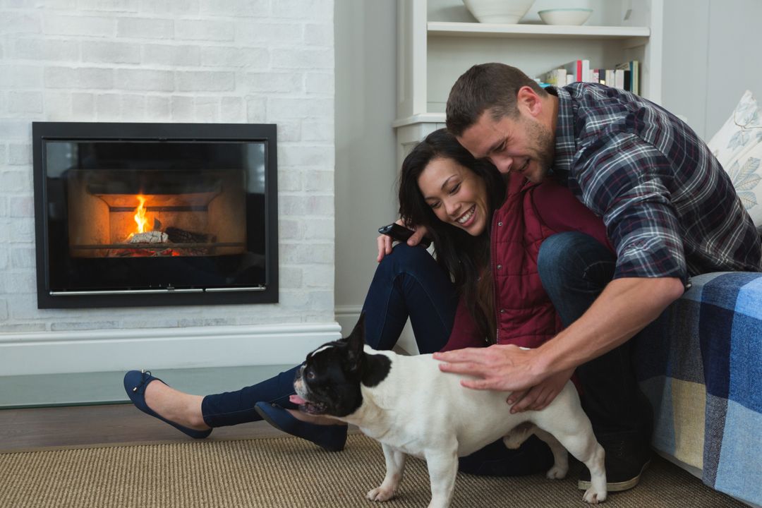 Couple Relaxing with Pet Dog by Fireplace at Home - Free Images, Stock Photos and Pictures on Pikwizard.com